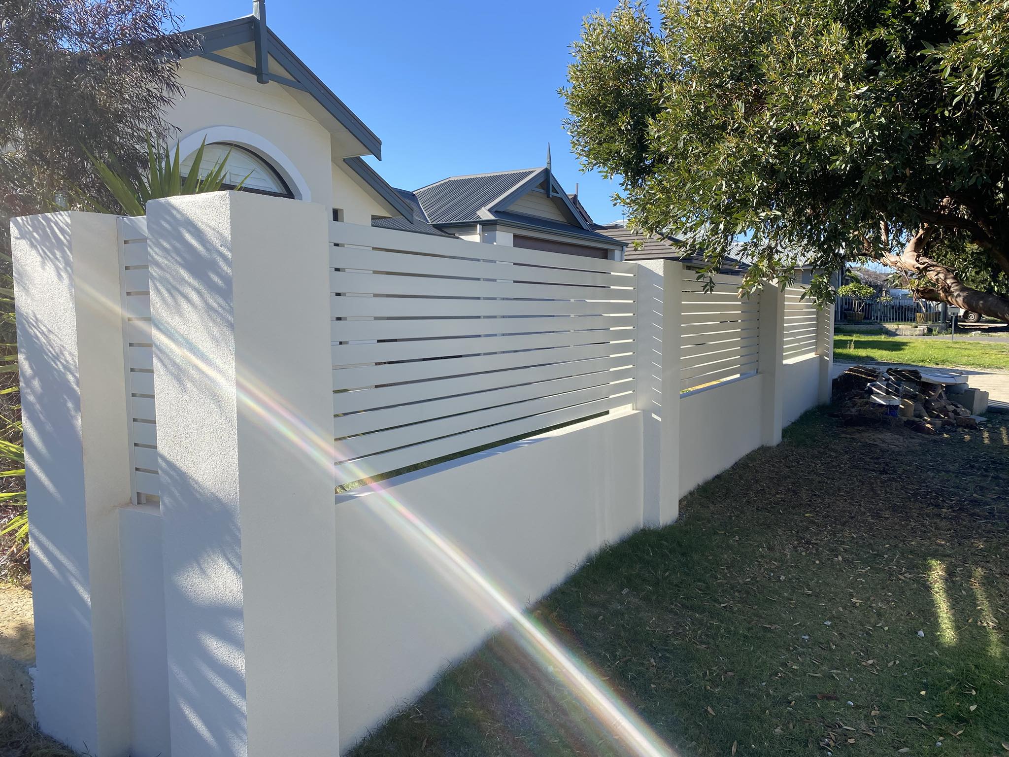 White aluminium slat-top fence on rendered piers across a front boundary in Perth